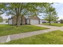 Traditional brick home with a two car garage and a long driveway with green grass at 4615 Copper Grove Dr, Indianapolis, IN 46237