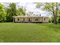 Charming home with a well-manicured lawn, covered porch with a porch swing and an eye-catching red front door at 503 E Bunker Hill Rd, Mooresville, IN 46158