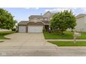 Beautiful two-story home with a three car garage, stone accents, landscaped yard, and a mailbox at 5593 Ralfe Rd, Indianapolis, IN 46234