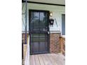 Close-up of front door with security screen and mailbox, set against a brick facade at 5605 Glencoe St, Indianapolis, IN 46226