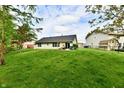 Level backyard features mature trees and a well-manicured lawn at 5611 Burning Tree Ct, Indianapolis, IN 46239