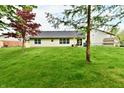 Expansive backyard features a well-manicured lawn and mature trees at 5611 Burning Tree Ct, Indianapolis, IN 46239