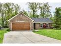 Brick home with a well-kept lawn and attached garage at 5611 Burning Tree Ct, Indianapolis, IN 46239