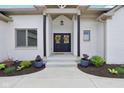 Covered front entrance featuring double doors, landscaping, and a concrete walkway at 5667 Skylark Dr, Greenwood, IN 46143