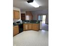 Well-lit kitchen featuring tiled floors, wooden cabinets and black appliances at 636 Mallards Xing # 2-A, Martinsville, IN 46151