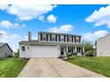 Attractive two-story home boasts white-painted brick, an attached two-car garage, and a green lawn at 6624 Lakestone Ct, Indianapolis, IN 46237