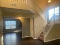 Bright foyer with hardwood floors, staircase, and an open view to living spaces at 6625 Wolverine Way, Indianapolis, IN 46237