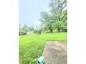 Lush backyard featuring mature trees, a playground, and storage shed at 7109 Chandler Dr, Indianapolis, IN 46217