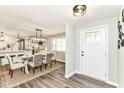 Open-concept dining area featuring modern lighting, wood-look floors, and seamless access to the kitchen at 7118 Mikesell Dr, Indianapolis, IN 46260