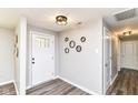 Bright foyer with wood-look floors, decorative mirrors, and a front door with glass panes at 7118 Mikesell Dr, Indianapolis, IN 46260