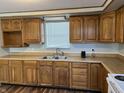 Kitchen featuring classic wood cabinets, modern sink, and ample counter space perfect for cooking at 7131 E 14Th St, Indianapolis, IN 46219