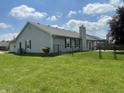 Spacious fenced backyard with a covered patio and a well-maintained lawn, ideal for outdoor activities at 8234 Crosser Dr, Indianapolis, IN 46237