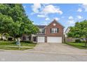 Charming brick home featuring a well-maintained lawn, mature trees, and an attached two-car garage at 8316 Thorn Bend Dr, Indianapolis, IN 46278