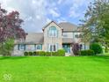 Charming two-story brick home with a lush green lawn and mature trees at 8798 Surrey Dr, Pendleton, IN 46064