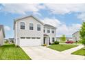 Attractive two-story home showcasing a manicured lawn, spacious driveway, and convenient two-car garage at 900 Sunchaser Rd, Lebanon, IN 46052