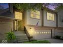 Inviting townhome entrance with decorative door and sidelight plus an attached garage with decorative windows at 9317 Muir Ln, Fishers, IN 46037
