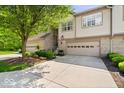 Well-maintained townhome with a lovely landscaped yard, inviting entrance, and attached garage with decorative windows at 9317 Muir Ln, Fishers, IN 46037