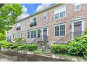 Street view of townhouses with tidy landscaping, stone steps, and wrought iron details at 952 Junction Pl, Indianapolis, IN 46220