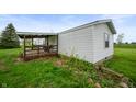 Exterior view of a home with white siding and a covered wooden deck at 9621 N County Road 25 W, Muncie, IN 47303
