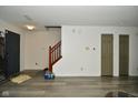 Spacious basement area with wood-look flooring, staircase, neutral walls, and access to storage rooms at 9955 Orange Blossom Trl, Fishers, IN 46038