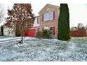 Charming two-story home with well-maintained lawn and landscape; red garage door and brick accents add a pop of color at 9955 Orange Blossom Trl, Fishers, IN 46038