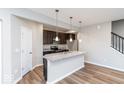 Bright kitchen featuring a center island with sink, granite countertops, and dark cabinetry at 10307 Gateway Dr, Brownsburg, IN 46234