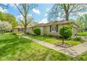 Beautiful stone home featuring a lamp post, trimmed bushes, and well kept lawn at 10827 Wonderland Dr, Indianapolis, IN 46239
