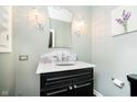 Elegant powder room with marble countertop vanity, stylish sconces, and a decorative mirror at 11319 Shoreview Ln, Indianapolis, IN 46236