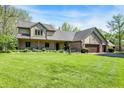 Beautiful home features a lush green lawn and a covered front porch at 11471 Clarkston Rd, Zionsville, IN 46077