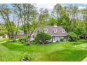 Beautifully landscaped lawn and charming gray home, complete with mature trees and inviting curb appeal at 11550 Clarkston Rd, Zionsville, IN 46077