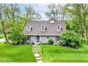 Beautiful gray home with manicured lawn, mature trees, and blue front door that welcomes you home at 11550 Clarkston Rd, Zionsville, IN 46077