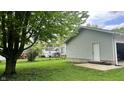 A spacious backyard with a detached garage and a glimpse of the home's exterior at 1202 S Ribble Ave, Muncie, IN 47302