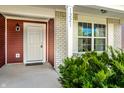 Inviting front porch with brick accents, a white door, and green bushes enhancing curb appeal at 1221 Danielle Rd, Lebanon, IN 46052