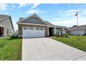 Charming brick home featuring a two-car garage and a welcoming front porch at 1401 Blackthorne N Trl, Plainfield, IN 46168
