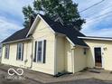 The back exterior elevation of the two story home features yellow siding and a dark shingled roof at 1440 E Morgan E St, Martinsville, IN 46151