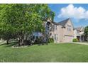 Lovely two-story home with a well-maintained lawn, mature trees, and a welcoming green front door at 1454 Woodfield Dr, Greenwood, IN 46143