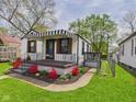 Charming home with striped awning, landscaped flower beds, and a well-maintained lawn at 1505 E 30Th St, Anderson, IN 46016