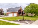 Beautiful two-story brick home with a three-car garage and manicured landscaping at 1510 Continental Dr, Zionsville, IN 46077