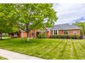 Well-maintained two-story brick home featuring lush green lawn and mature trees at 1510 Continental Dr, Zionsville, IN 46077