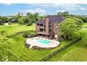 Expansive backyard features a sparkling swimming pool, lush lawn, and mature trees, perfect for outdoor enjoyment at 16285 Remington Dr, Fishers, IN 46037
