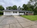 A well-maintained ranch-style home featuring an attached garage and a manicured front yard at 1949 Shenandoah Pl, Indianapolis, IN 46229
