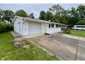 Side view showing the home's siding, attached garage, and concrete driveway at 1949 Shenandoah Pl, Indianapolis, IN 46229