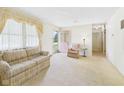Bright living room featuring neutral carpet, large windows with decorative curtains and a comfortable seating arrangement at 209 E 35Th St, Anderson, IN 46013