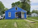 View of bright blue house with manicured lawn and walkway to front door at 2737 S Roena St, Indianapolis, IN 46241