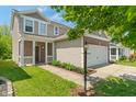 Attractive two-story home with a welcoming front porch, neat landscaping, and attached two-car garage at 4136 Orchard Valley Ln, Indianapolis, IN 46235