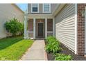 Close up of front porch with brick facade, white pillars, and a well-maintained garden at 4136 Orchard Valley Ln, Indianapolis, IN 46235
