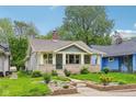 Charming bungalow featuring stone accents, landscaped front yard, and a welcoming front porch at 4245 Guilford Ave, Indianapolis, IN 46205
