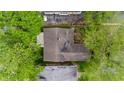 Birds-eye view of a home with a dark brown roof surrounded by mature green trees, and other houses at 425 S Oakland Ave, Indianapolis, IN 46201