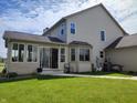Well-maintained backyard with lush green grass, a covered patio, and siding at 4719 Arabian Run, Indianapolis, IN 46228
