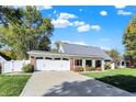 View of a charming one-story home featuring an attached garage and well-manicured front lawn at 51 Wilson Dr, Carmel, IN 46032